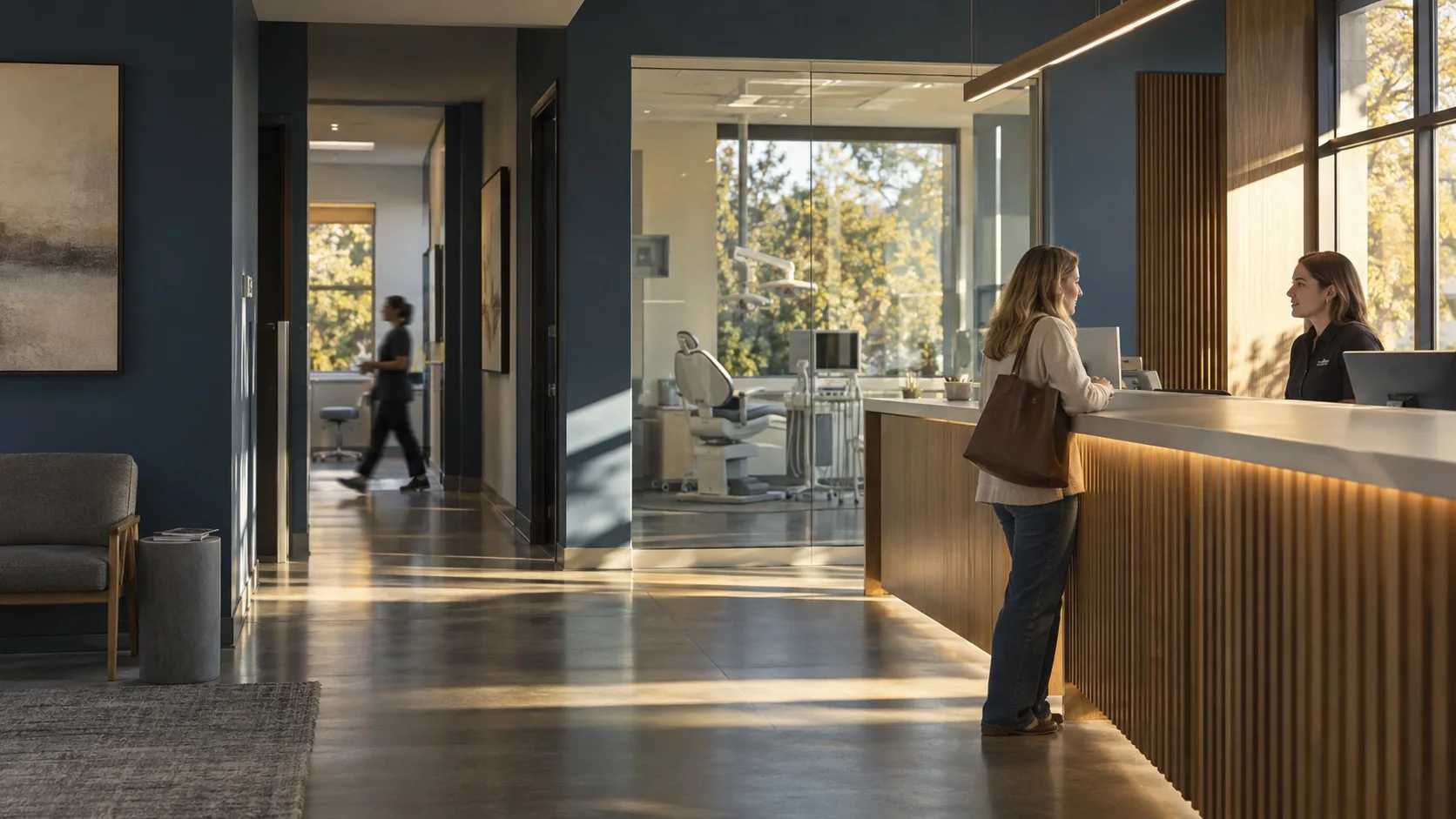 A patient checking in at the front desk of a bright dental practice in late-afternoon light